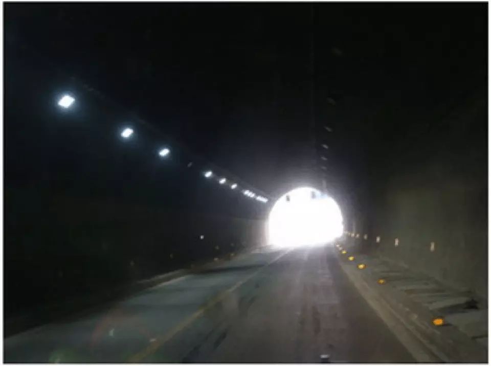 如图所示，驾驶机动车行经该路段时，应减速慢行，避免因眩目导致的交通事故。