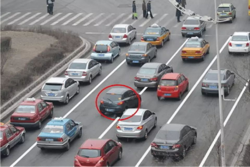 如图所示，红圈标注的深色车辆的做法是违法的。