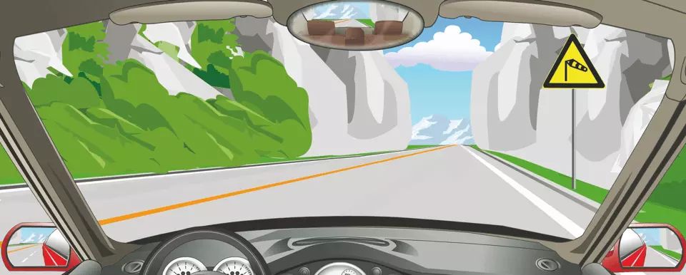 右侧这个标志提醒前方山口注意横风。